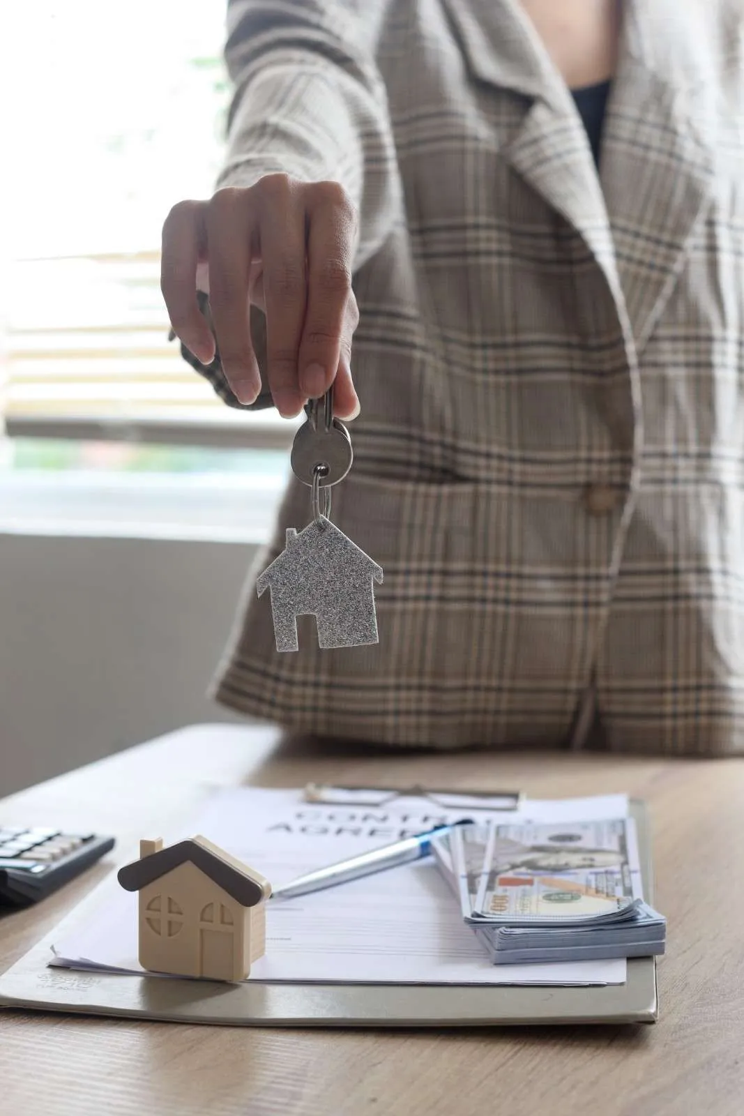 Hand placing a key on a kitchen counter